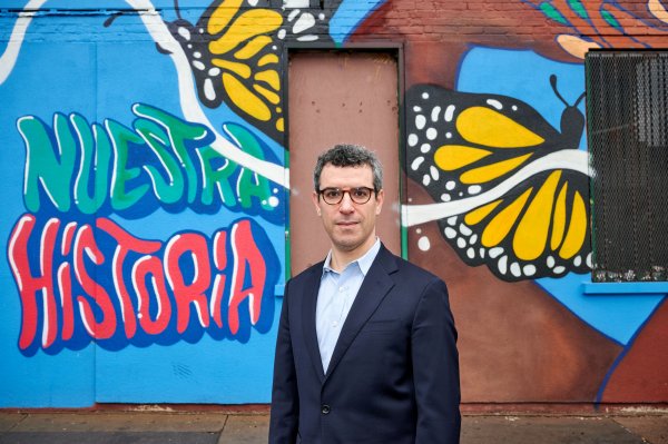 Andy Horowitz, state historian and associate professor of history, stands near a mural on Broad Street in Hartford on Feb. 23, 2024. (Peter Morenus/UConn Photo)